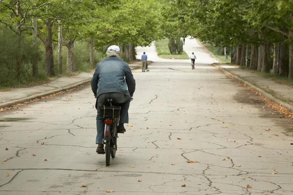 Old person riding through the park — Stock Photo, Image