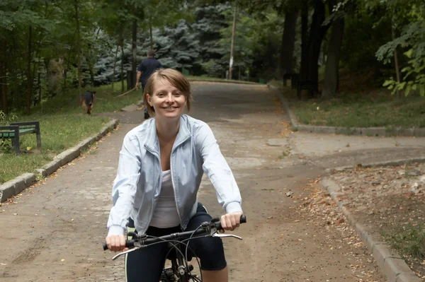 若い女性乗馬笑みを浮かべてバイク — ストック写真