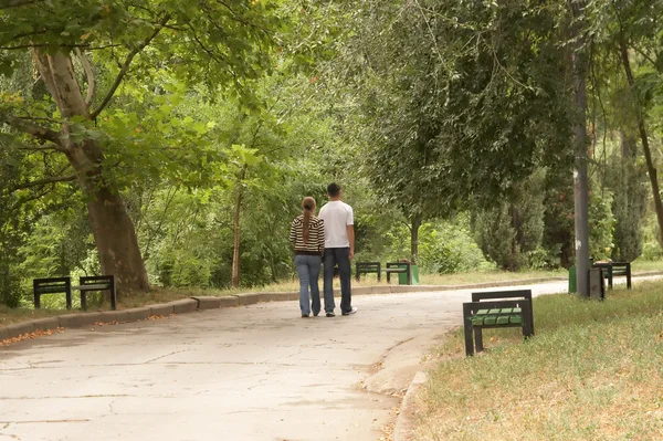 Молодая пара, гуляющая по парку — стоковое фото