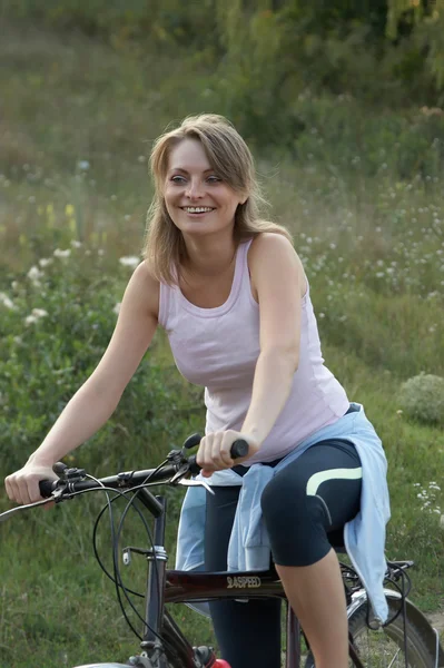 Mladá žena na koni usmívající se kolo — Stock fotografie