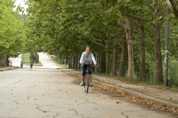 Jovem mulher andando de bicicleta sorridente Imagem De Stock