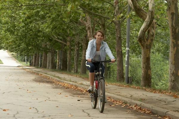 젊은 여성 승마 웃는 자전거 스톡 사진
