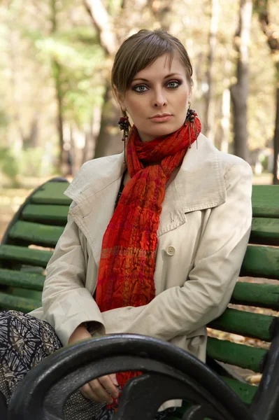 Ung kvinde sidder på bænken - Stock-foto