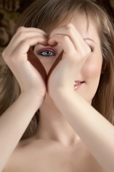 Beauty woman showing heart and looking t Stock Photo