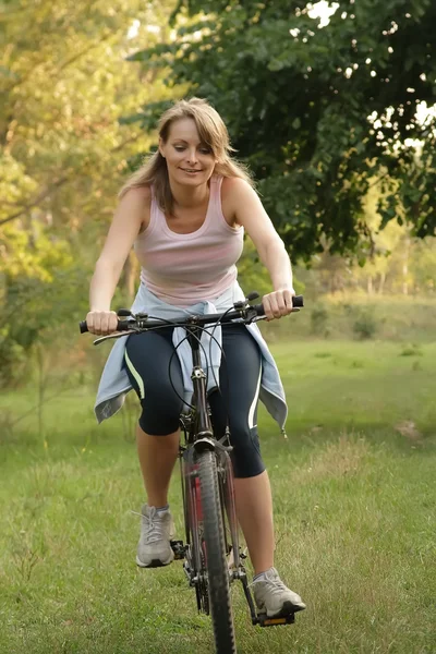 Γυναίκα ποδηλασία σε ένα πάρκο — Φωτογραφία Αρχείου