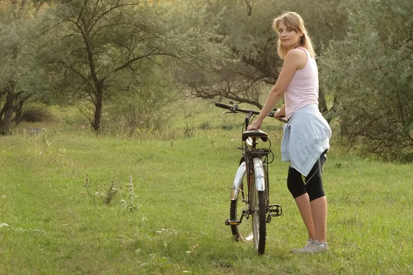 Donna in bicicletta in un parco Foto Stock