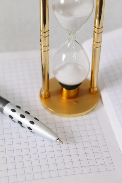 Sand-glas med penna och en Anteckn — Stockfoto