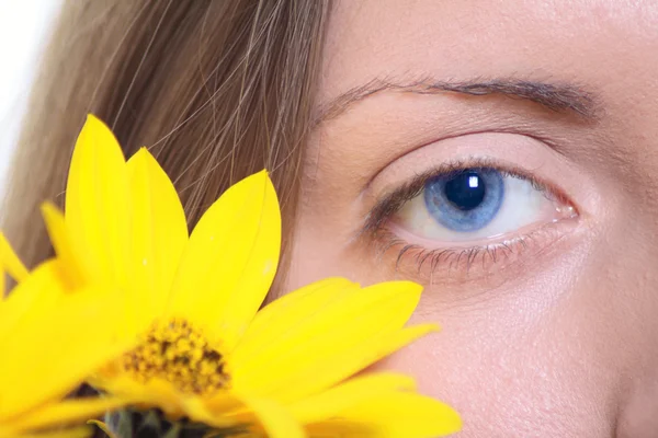 Kvinnliga ögat med en gul blomma — Stockfoto