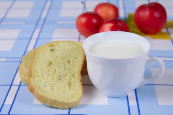 Cup of milk with a cornbread and apples — Stock Photo, Image