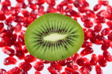 The cut fruit kiwi against garnet grains clipart