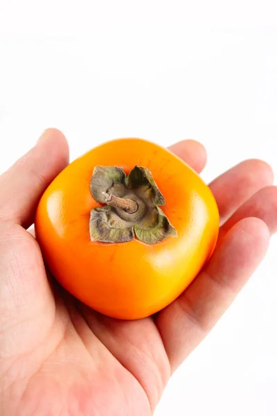 Persimmon in a man's hand — Stock Photo, Image
