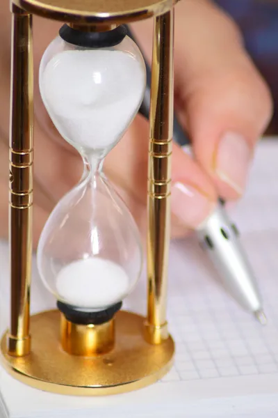 Horloge de sable et main féminine avec stylo — Photo