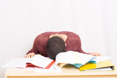 Young man sleeping oh his books clipart