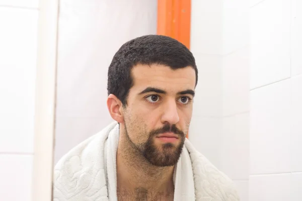 Muž se holí a dívá se do zrcadla — Stock fotografie