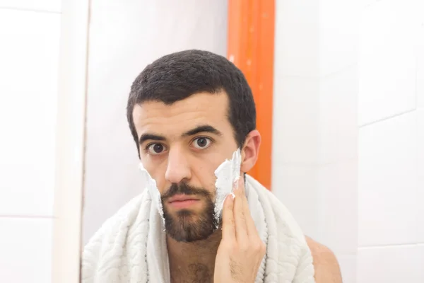 Az ember borotválkozik és tükörbe néz. — Stock Fotó