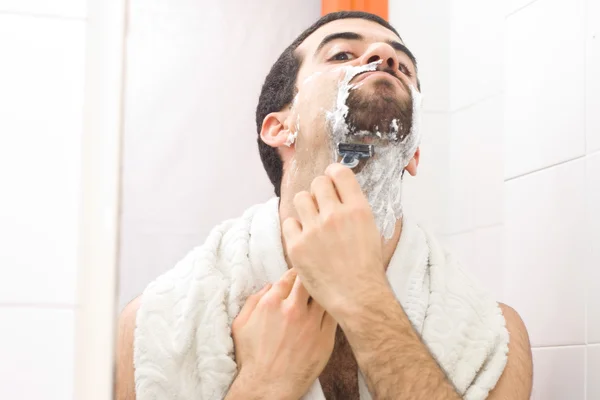 Homem fazendo a barba e olhando para o espelho — Fotografia de Stock