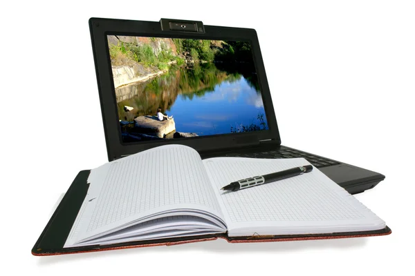 Laptop und Notizbuch auf weißem Hintergrund lizenzfreie Stockfotos