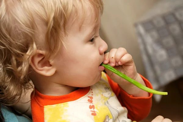 O menino come alho-porro — Fotografia de Stock