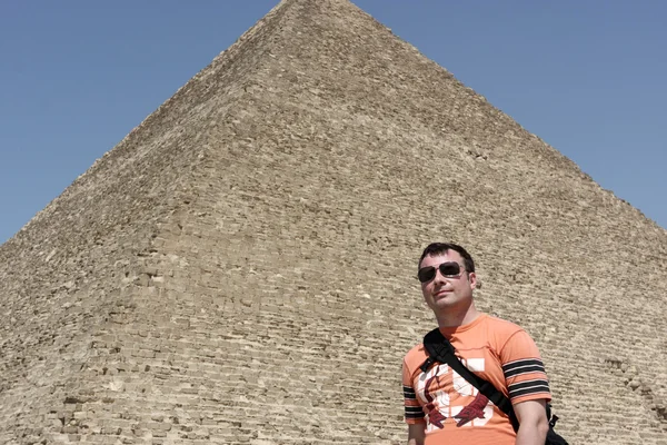 Человек на большом фоне пирамиды — стоковое фото