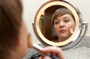 Girl puts on make-up clipart