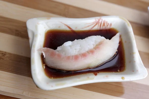 Sushi nigiri em molho de soja — Fotografia de Stock