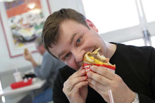 Hombre come hamburguesa — Foto de Stock