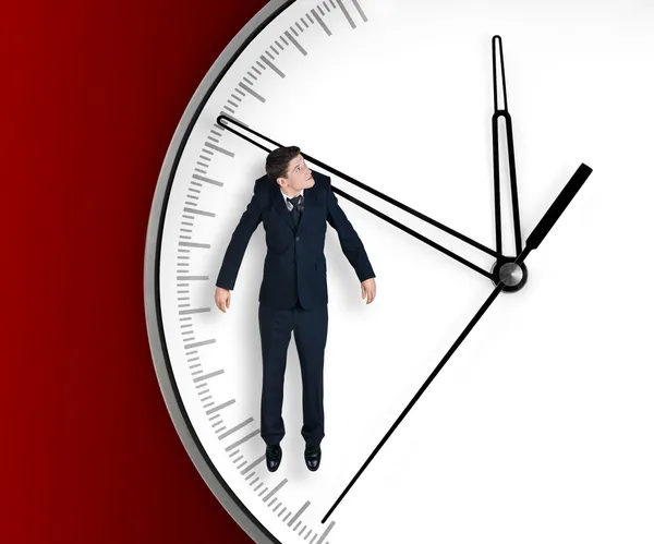 Homme d'affaires accroché à une flèche d'horloge — Photo