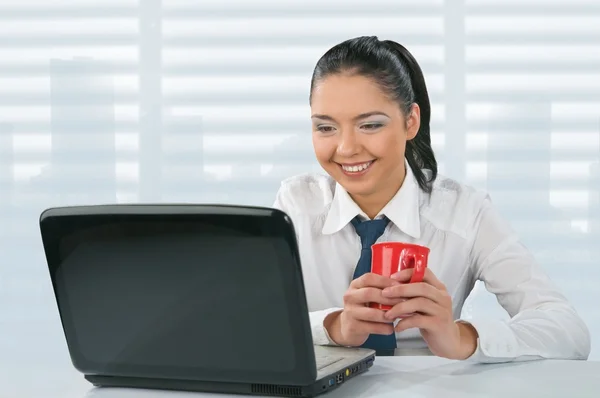 Mujer joven mira su computadora portátil —  Fotos de Stock