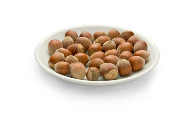 Ořechy v talíři, izolovaných na bílém pozadí — Stock fotografie