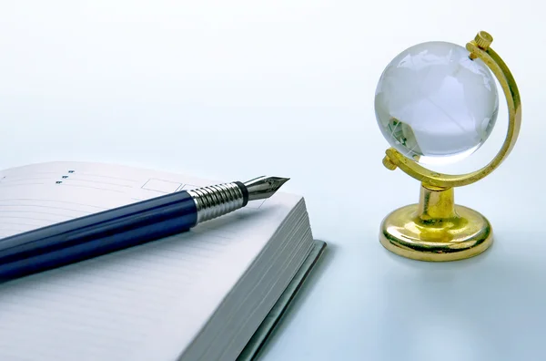 Ноутбук и ручка, глобус — стоковое фото