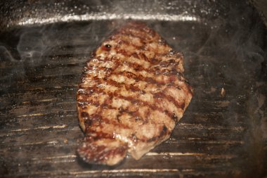 A top sirloin steak flame broiled on a barbecue, shallow depth of field. clipart