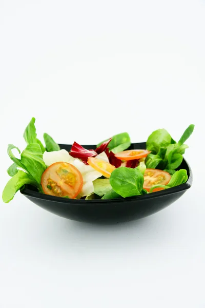 Греческий салат в черной тарелке — стоковое фото