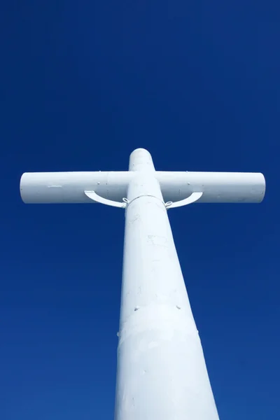 Vitt kors och kyrkan mot blå himmel — Stockfoto