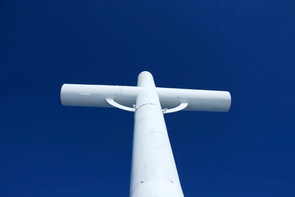 Белый крест и церковь против голубого неба — стоковое фото