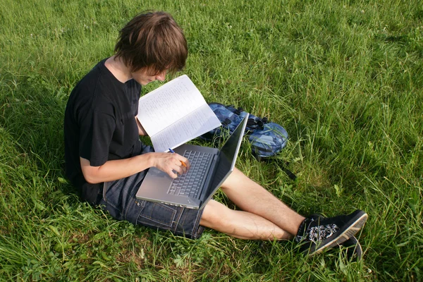 Студент в кампусе с книгами и ноутбуком . — стоковое фото