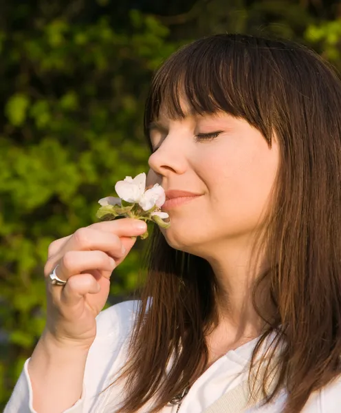 Ekte kvinne lukter blomst – stockfoto