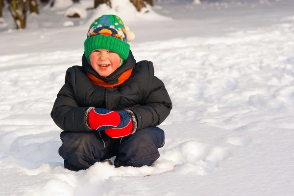 Liten pojke spelar i vinter skog — Stockfoto