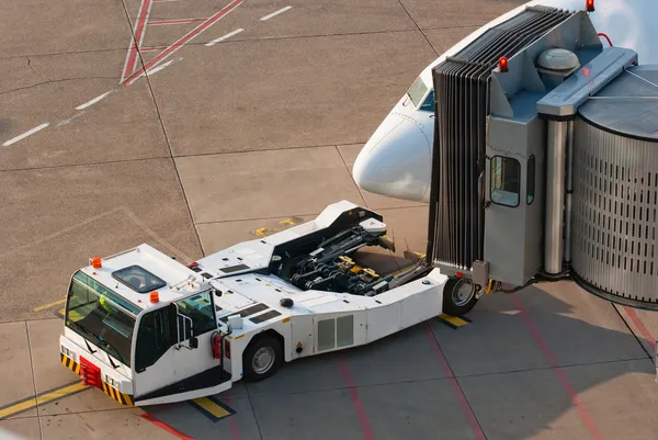 Port lotniczy. Jet i holowanie samochodów ciężarowych. — Zdjęcie stockowe