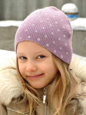 Happy little girl in a lilac hat. clipart