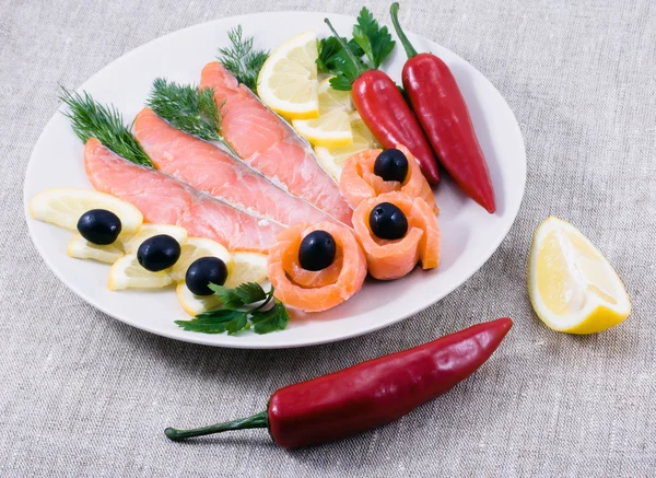 Красная рыба, лимон, оливки на тарелке — стоковое фото
