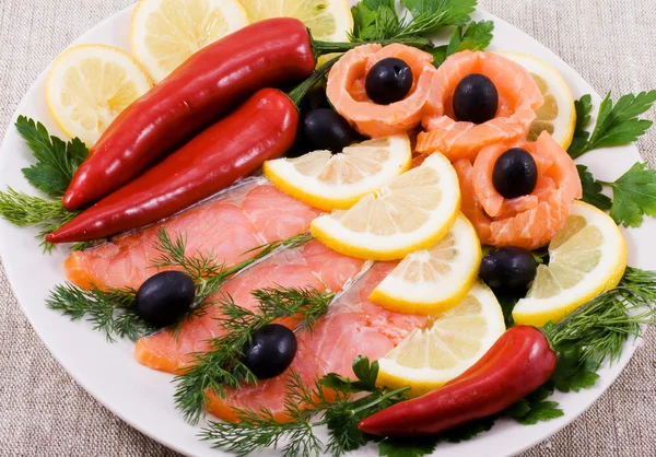 Czerwona ryba, cytryny, oliwki na talerzu — Zdjęcie stockowe