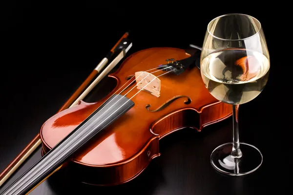 Violino e um copo de vinho na mesa — Fotografia de Stock