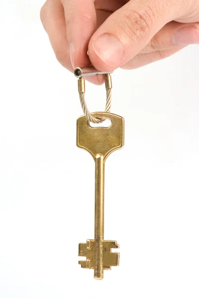 Mão segura uma chave de ouro — Fotografia de Stock