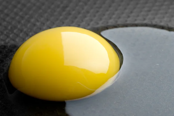 Trasiga ägg i en svart stekpanna — ストック写真