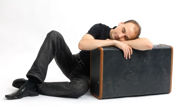 Мужчина спит на старом чемодане — стоковое фото
