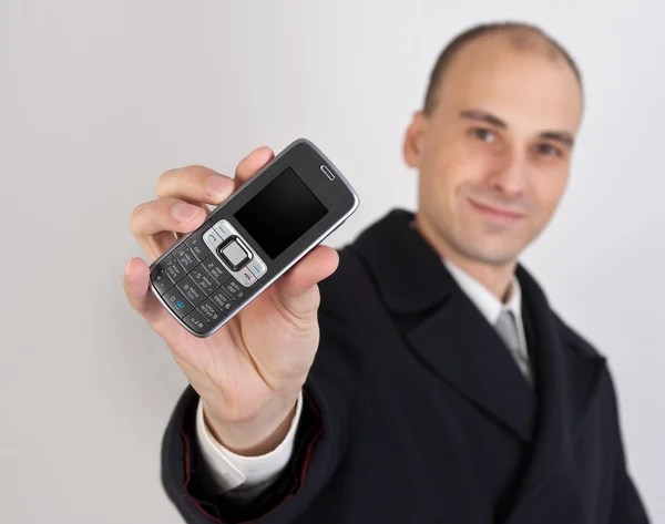 Empresario sosteniendo un teléfono móvil — Foto de Stock