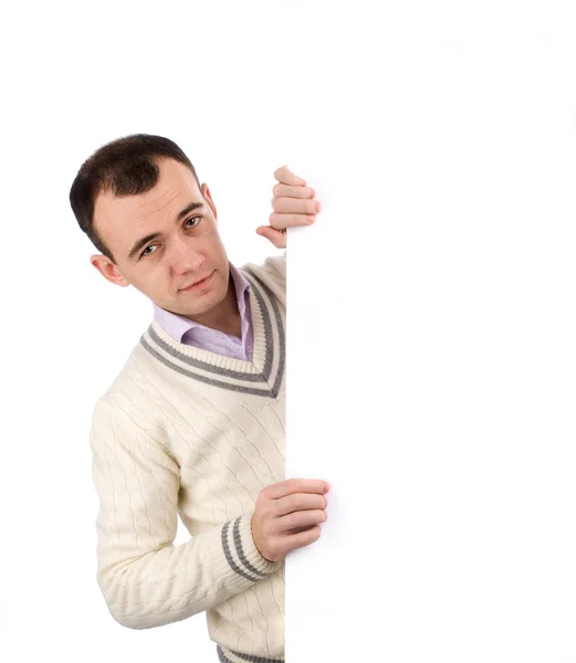 Young man standing by white blank card — Stock Photo, Image