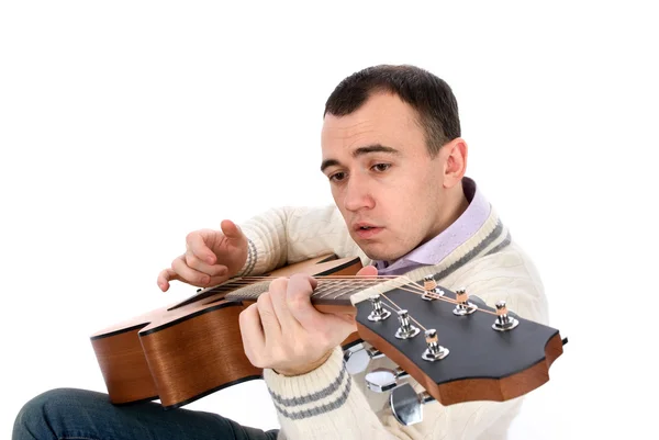 Молодой человек играет на акустической гитаре — стоковое фото