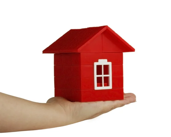 Red toy house on hand — Stock Photo, Image