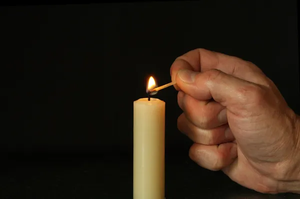 Hand zündet Kerze an — Stockfoto